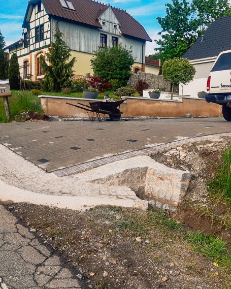 Landschaftsbau im Aufbau – saubere Fundamentarbeit für Außenanlagen Vorbereitende Arbeiten mit Naturstein und Mauerzug auf gepflastertem Gelände